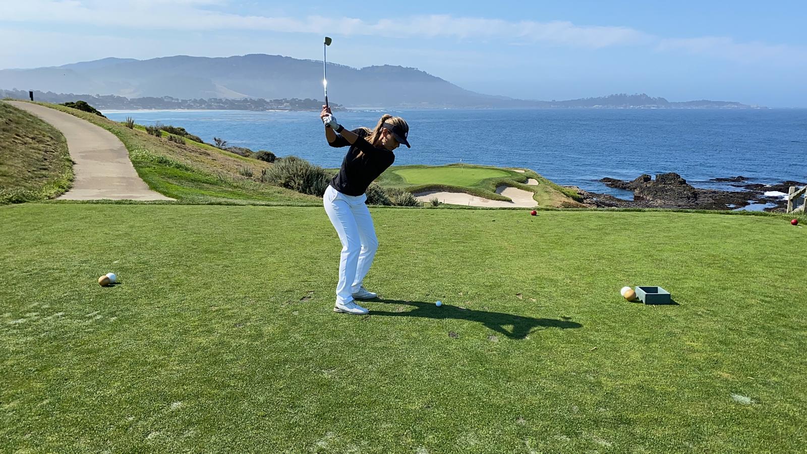Valeria playing golf on a coastal course