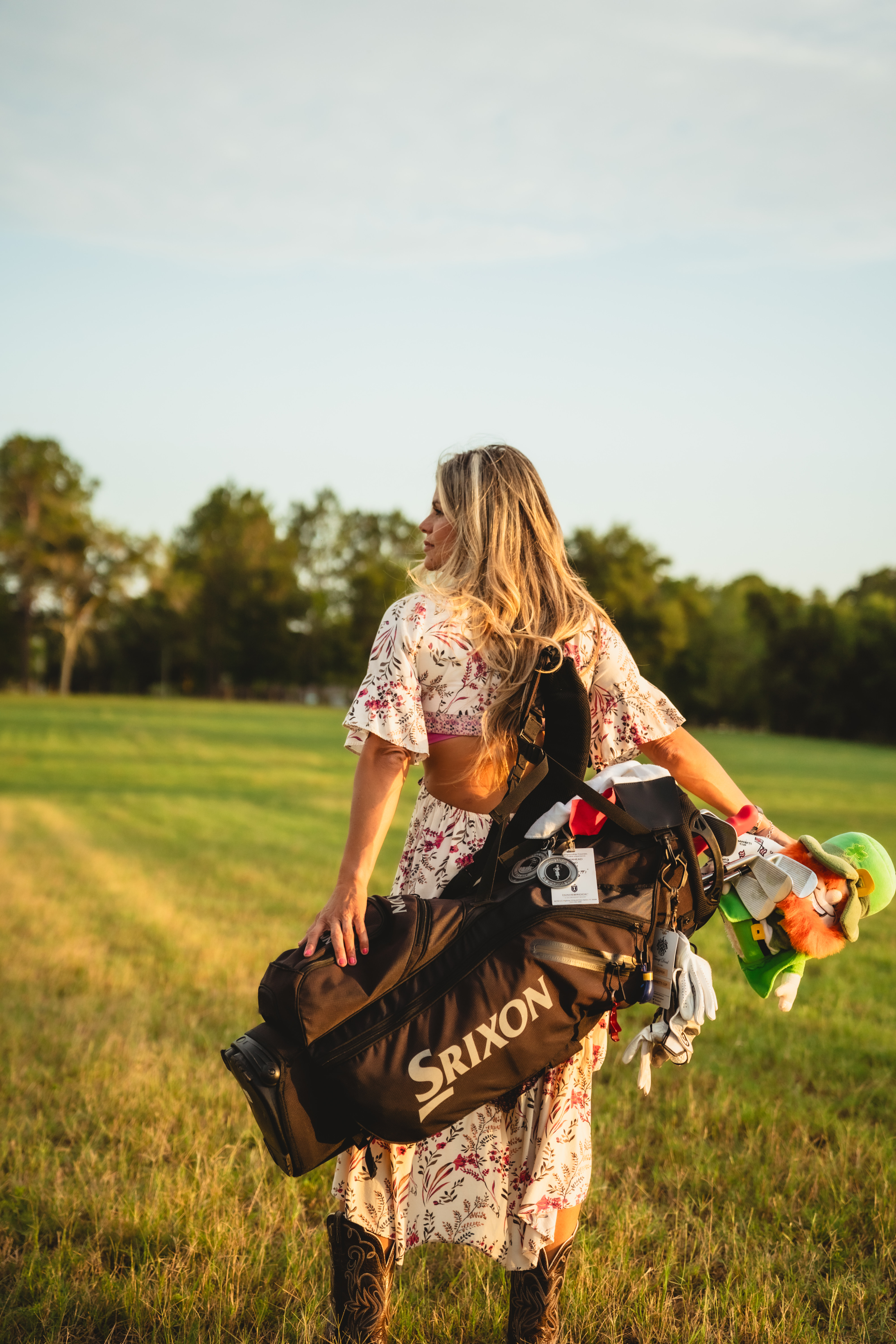 Valeria Brannen carrying her golf bag on a sunlit course
